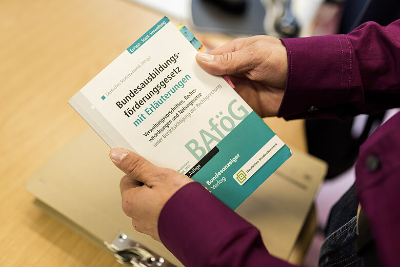 Person hält BAföG-Gesetzbuch