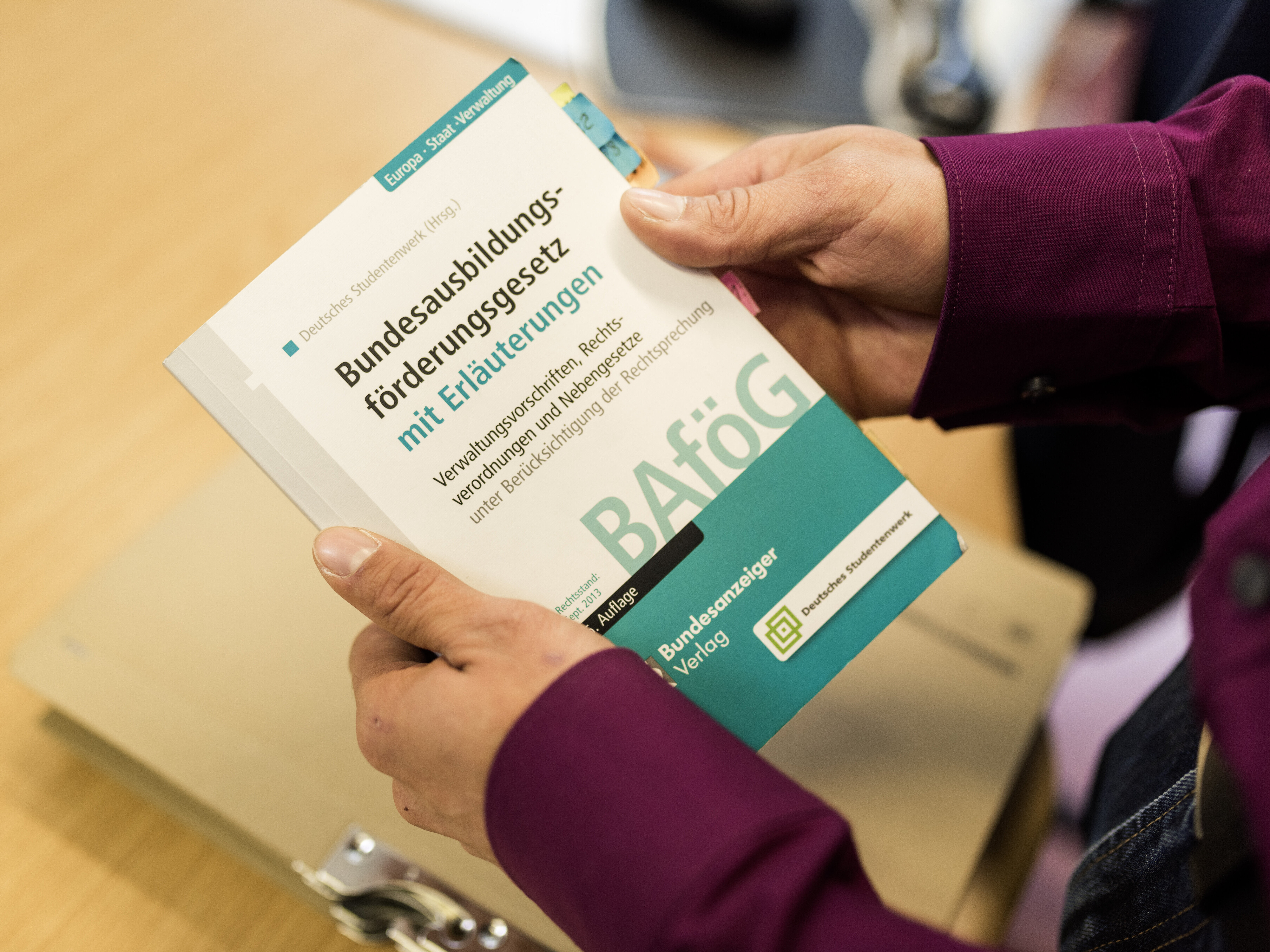 Person hält BAföG-Gesetzbuch