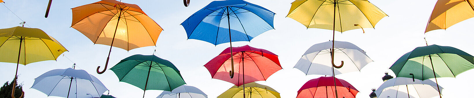Bunte Regenschirme schweben am Himmel
