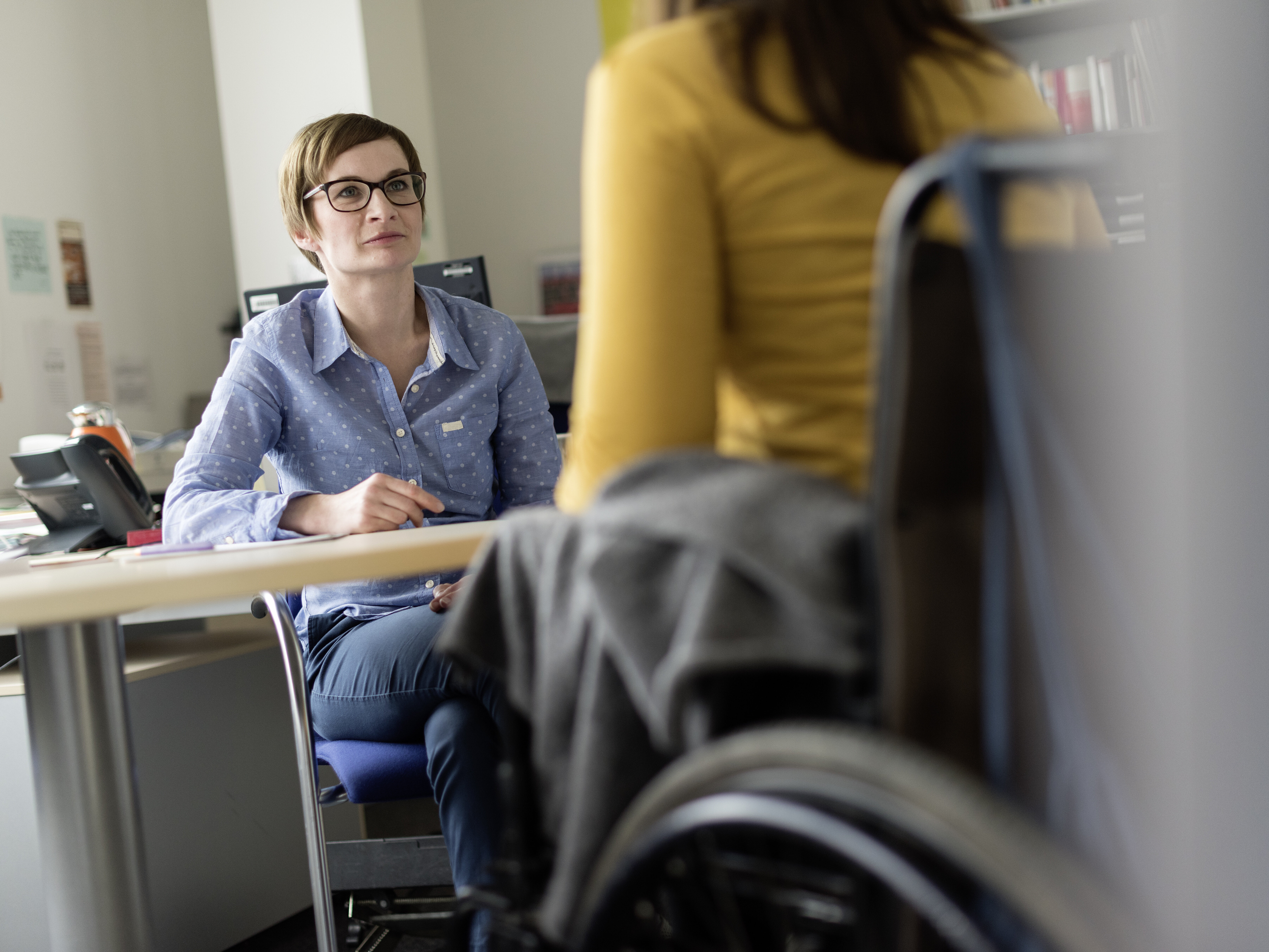 Studentin im Rollstuhl im Gespräch mit Beraterin