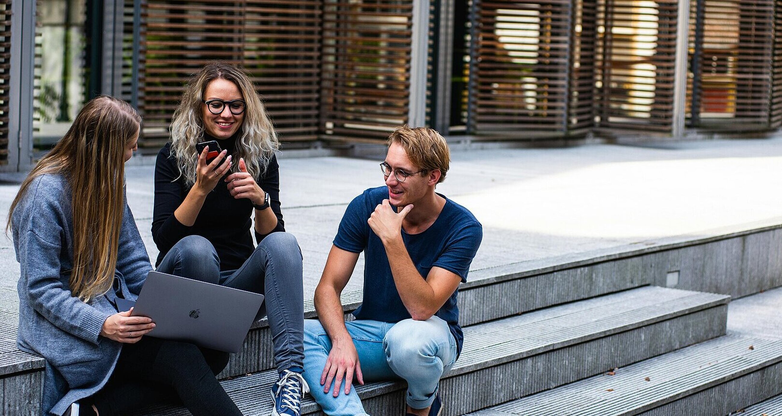drei junge Menschen unterhalten sich im Freien