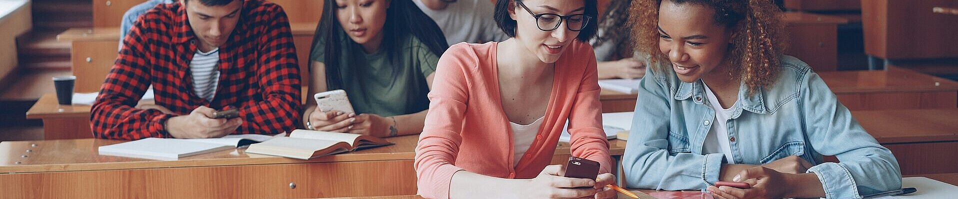 Studierende in einem Hörsaal nutzen Smartphones.