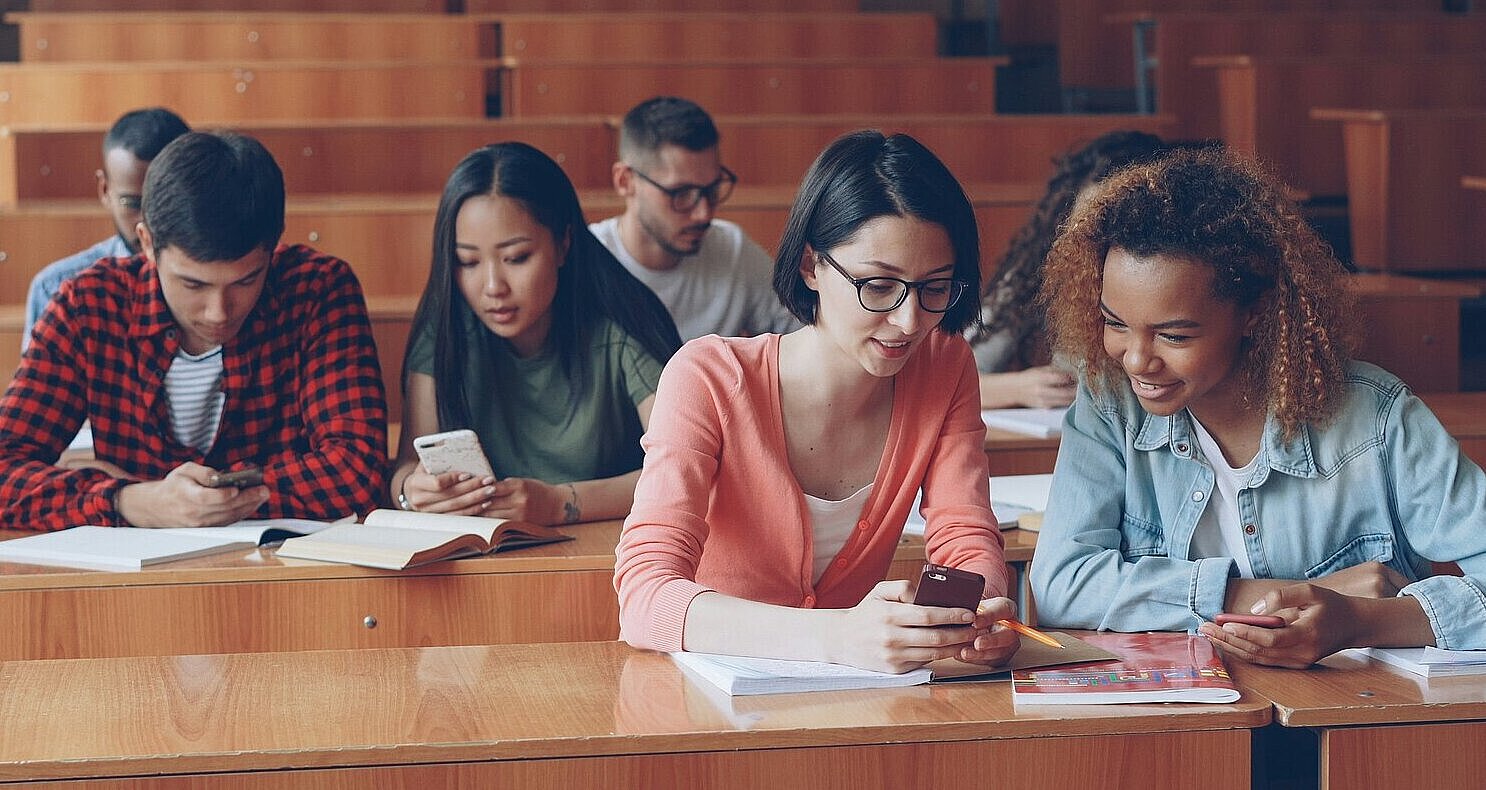 Studierende in einem Hörsaal nutzen Smartphones.