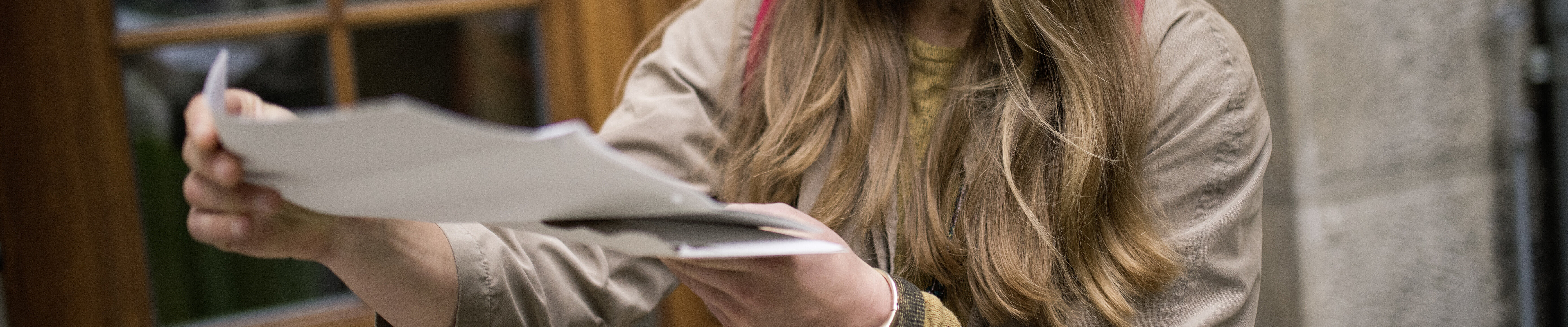 Frau liest einen gerade geöffneten Brief und freut sich