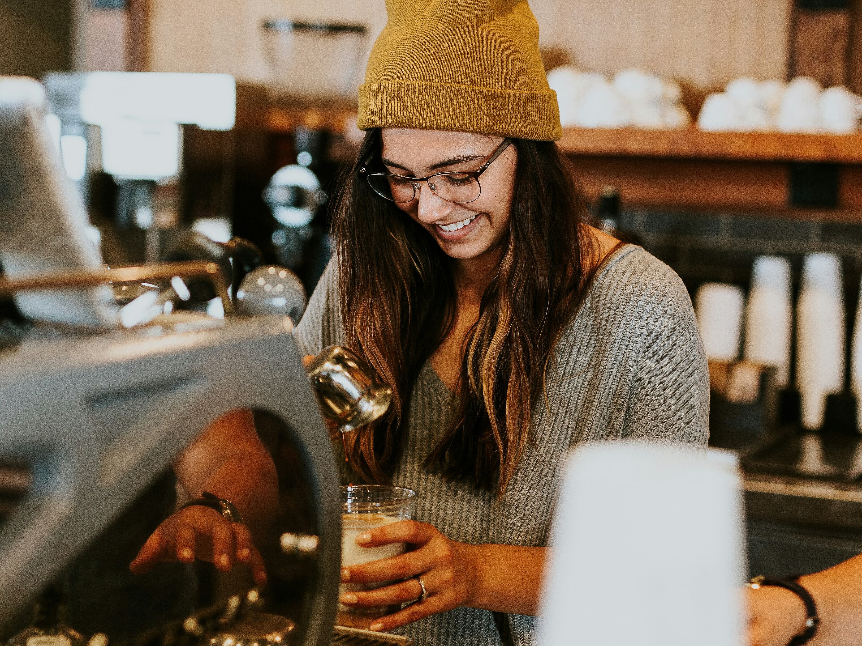 Junge Barista lächelnd hinterm Tresen