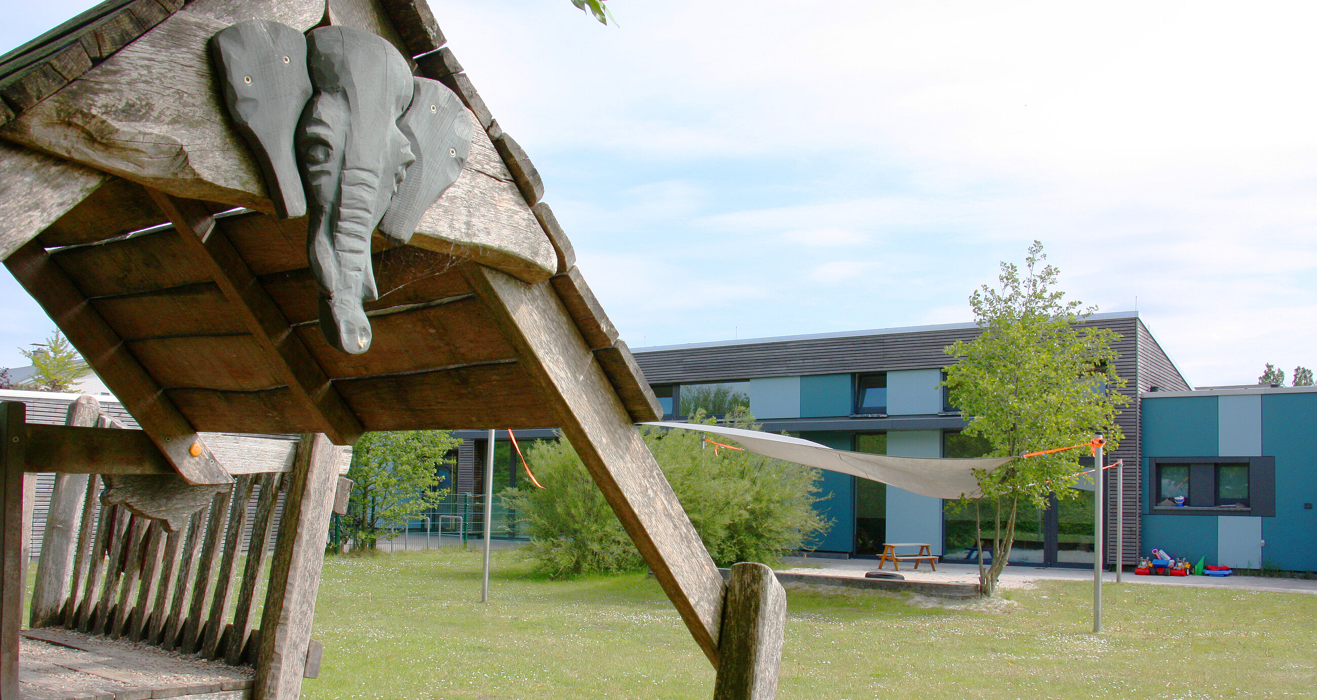 Im Vordergrund ein Spielhaus, im Hintergrund die Kita Constantia