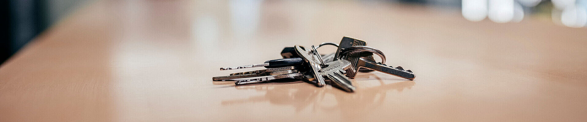 A bunch of keys lies on a table.