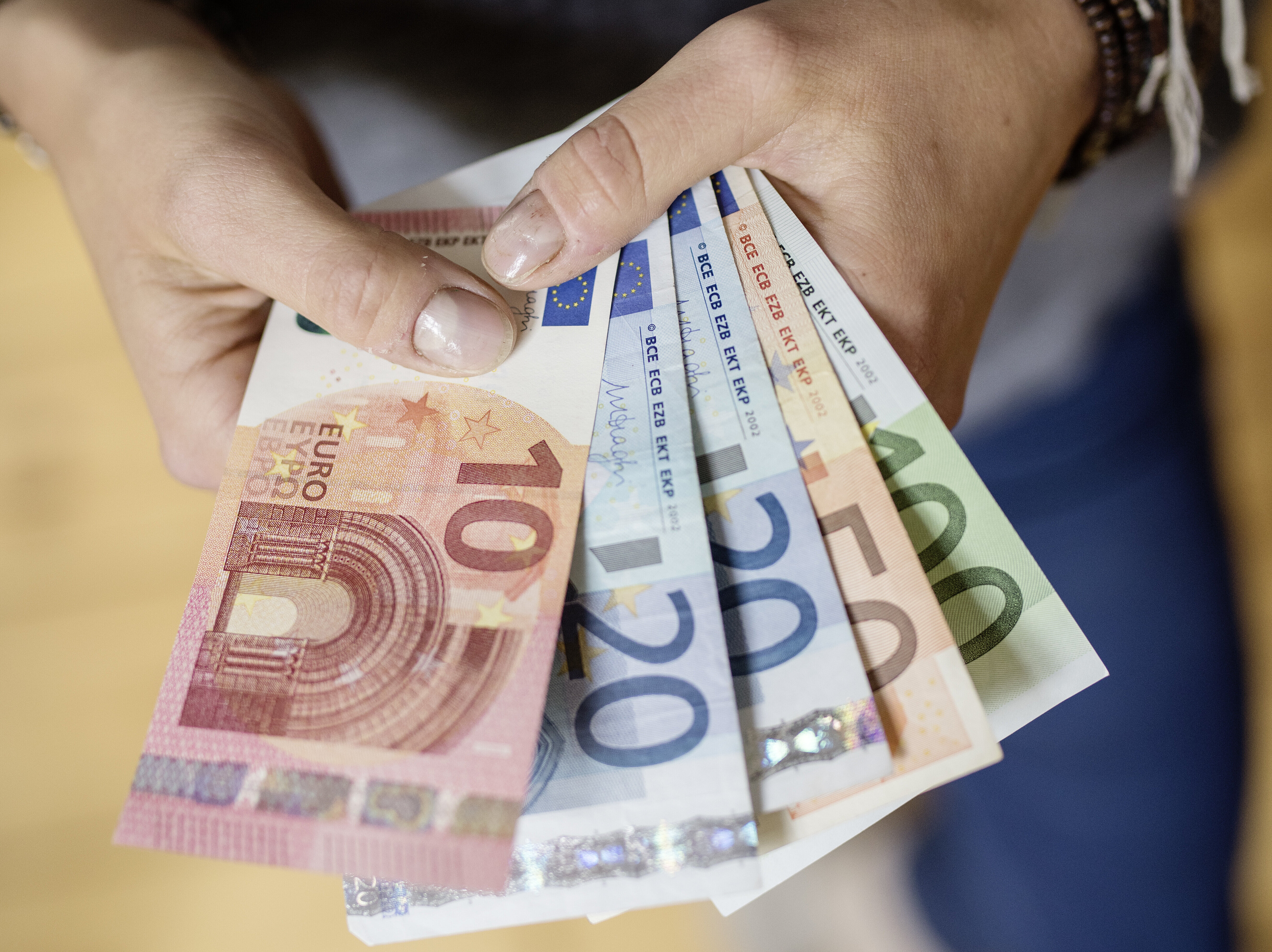 Eine Person hält Geldscheine in der Hand