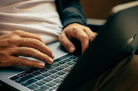 Nahaufnahme einer Person, die einen Laptop benutzt