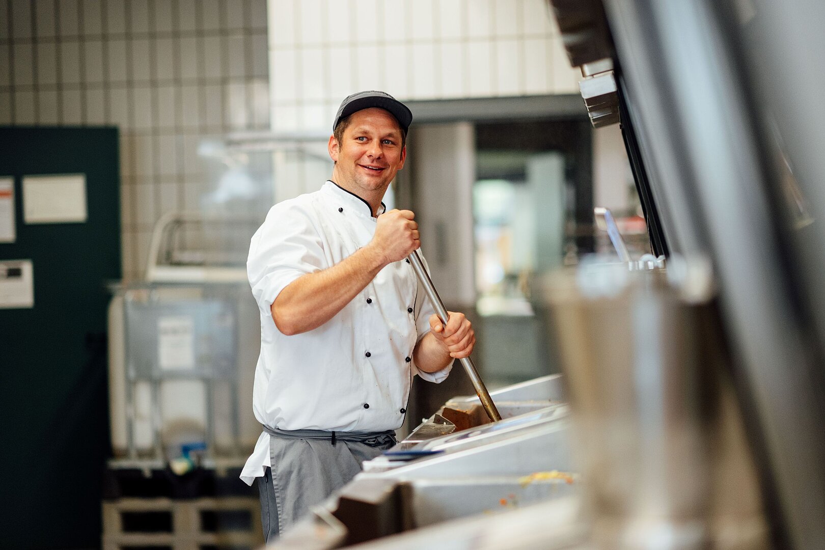 Koch in der Mensa-Küche