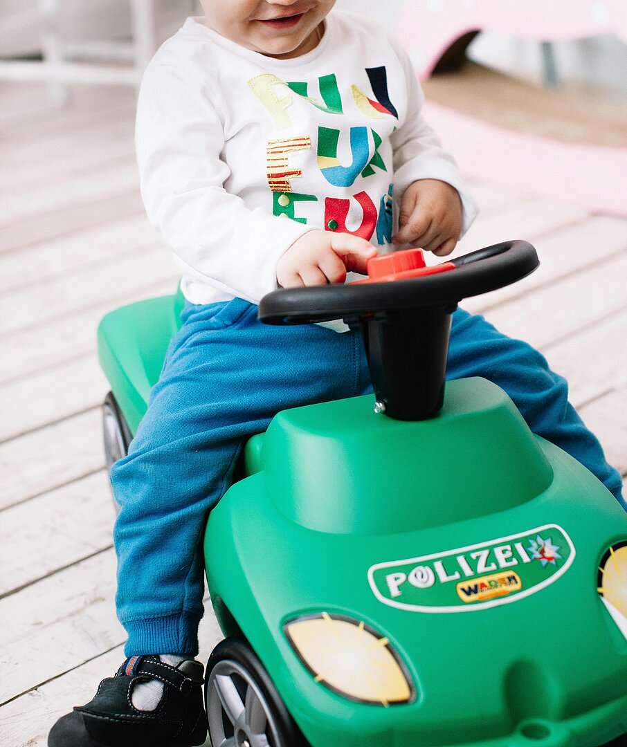 Kind auf Polizei-Bobbycar